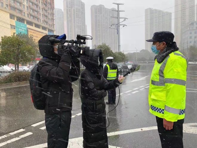 孝感市融媒體中心楊亞玲（風(fēng)雪中，采訪疫情期間重返一線的退休警察）_副本.jpg.jpg
